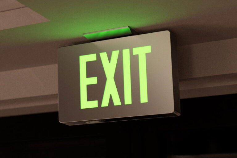 A photo of a green exit sign glowing after dark