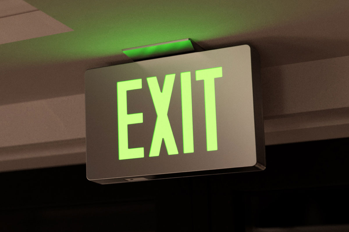 Requirements for Egress Marking: Regulations Related to Exit Signs and Wayfinding A photo of a green exit sign glowing after dark