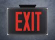 An Isolite exit sign covered by a protective plastic cover